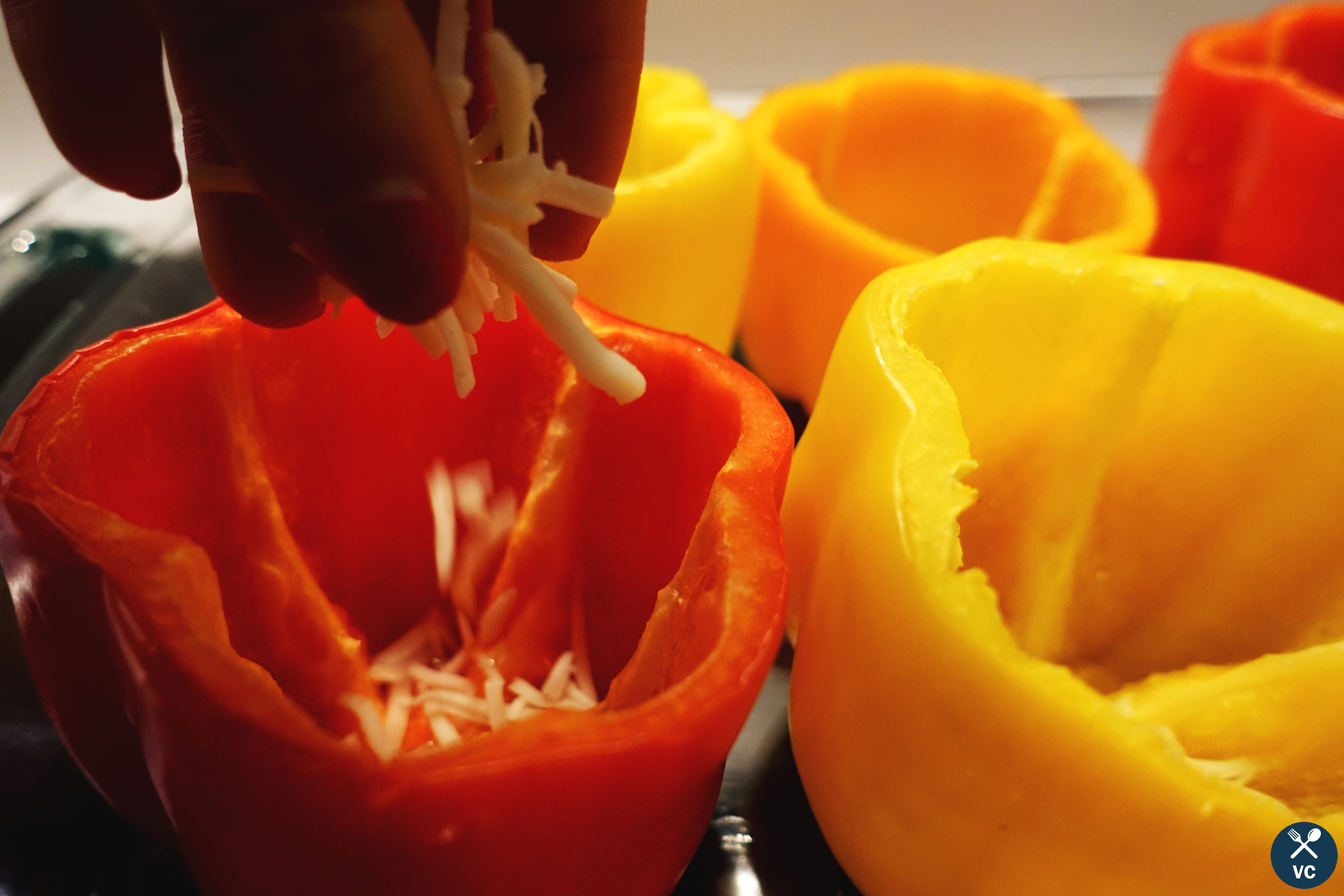 Adding cheese to the bottom of the turkey stuffed peppers (VC in the Kitchen)