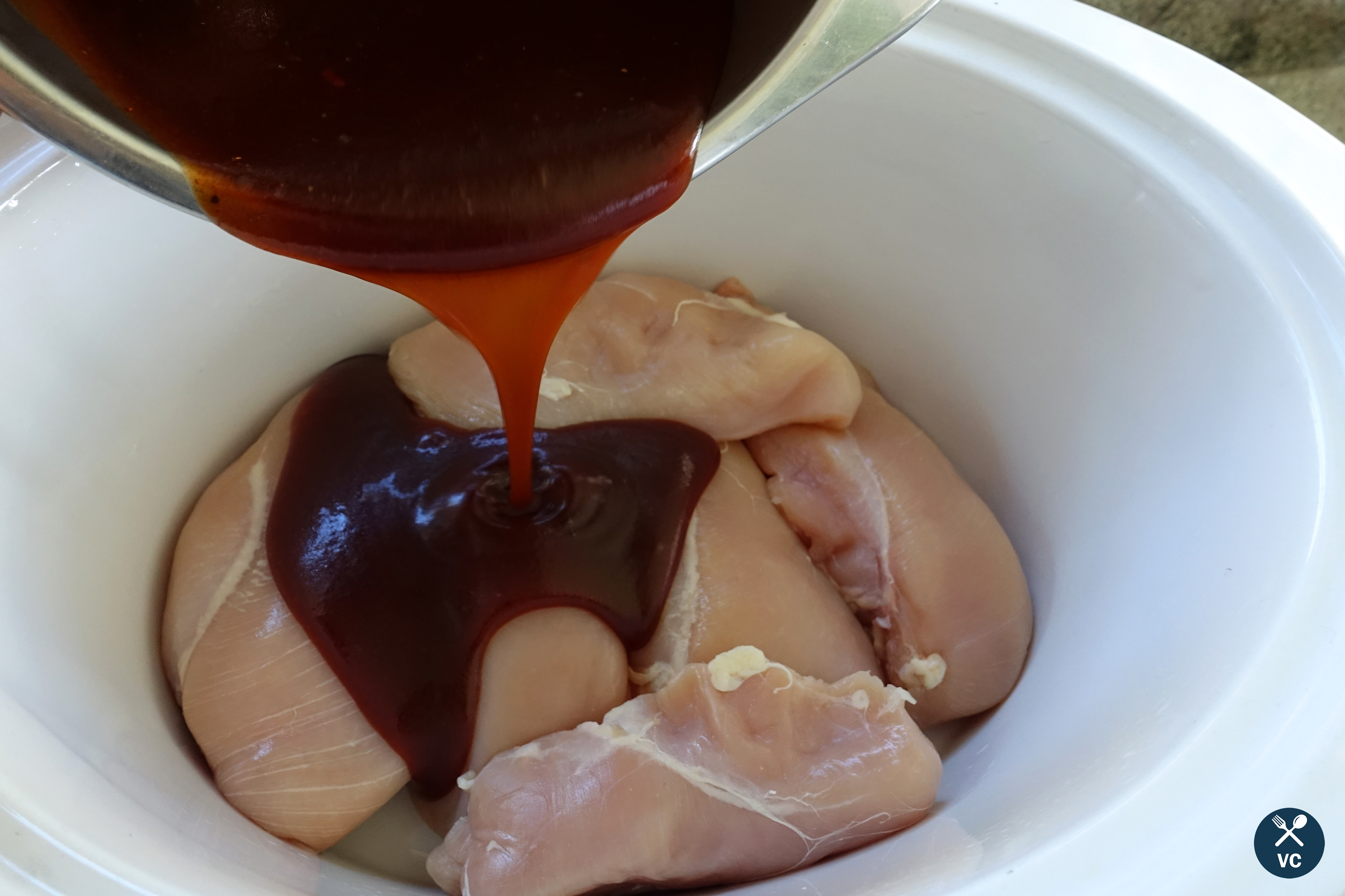 Bourbon BBQ sauce poured over chicken breasts for slow cooker bourbon BBQ chicken (VC in the Kitchen)