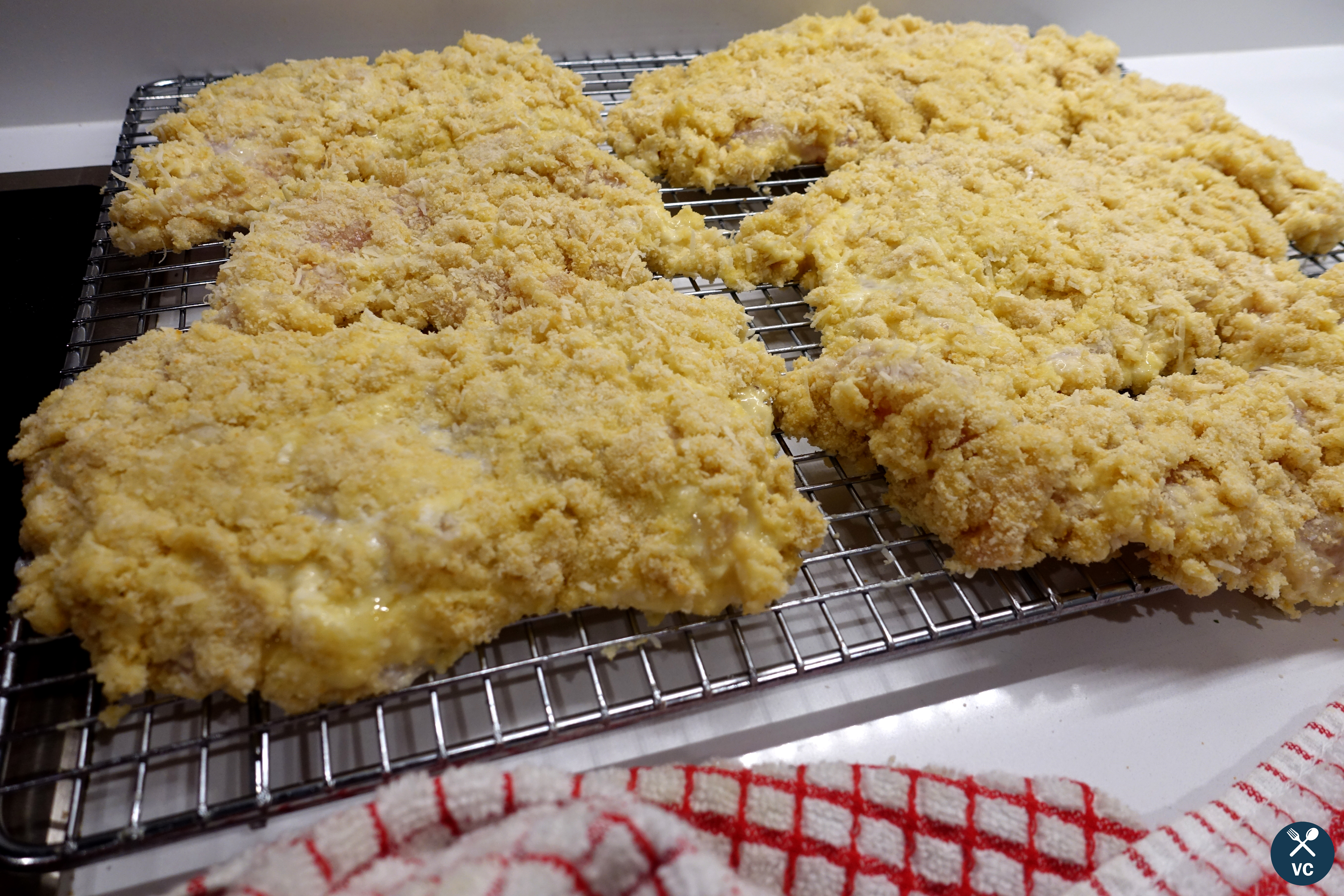 Breaded chicken parmesan cutlets resting on wire racks (VC in the Kitchen)